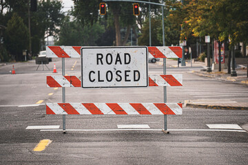 Road closed sign and barricade on empty street