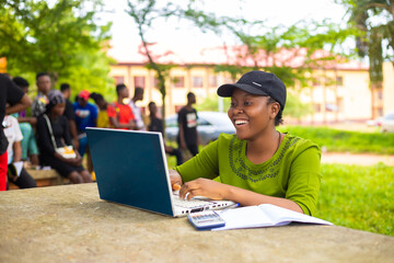 close up of a beautiful african lady studying in the school campus feeling excited