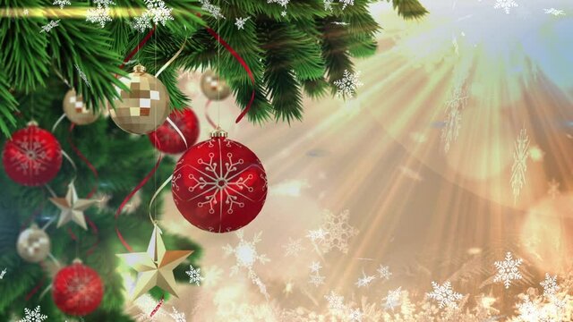 Animation of christmas boubles and snow falling over glowing light