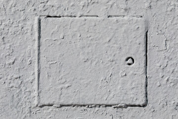 Concealed hatch painted gray in classic interior. Old textured hatch with lock.