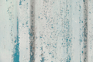 Cracked paint on the wall. grunge background. Old wall with cracked peeling paint. Weathered rough painted surface with patterns of cracks and peeling. Texture for background and design.