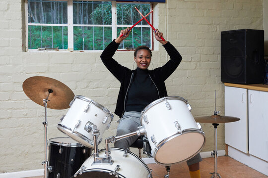 Black woman with short hair playing drums