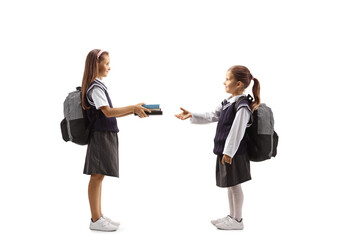 Fototapeta premium Schoolgirl giving books to another schoolgirl