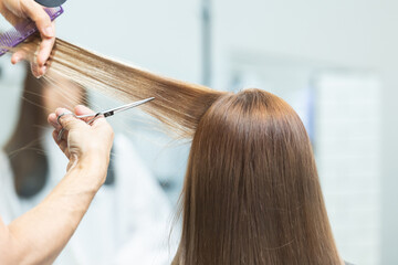 Fototapeta premium ヘアサロンで女性の髪の毛をカットするスタイリストの手元