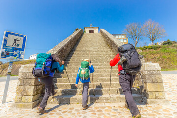 Two Adults and Child Pilgrims Ascending Stairs at City Entrance to Portomarin, along the Way of St...