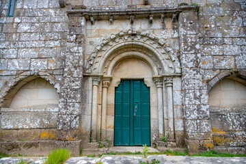 Fototapeta na wymiar Facade of the Medieval Pilgrim Church Santa Maria de Melide with Closed Green Door on the Way of St James Pilgrimage Trail Camino de Santiago