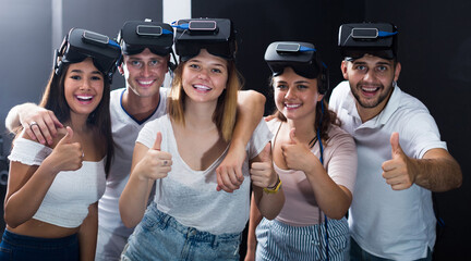 Young italian people using virtual reality glasses delighted with videogames and new tech.