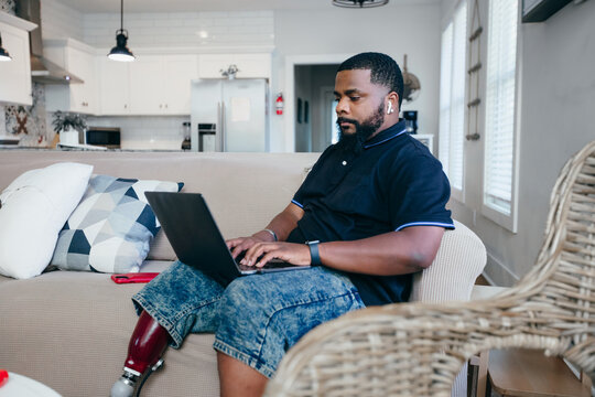 African American man working from home on laptop, disability 