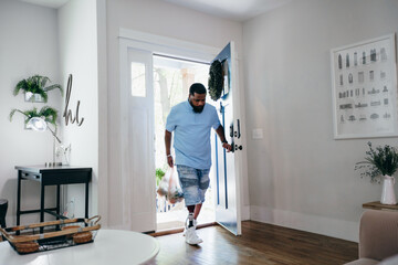 Black man with prosthetic leg bringing home groceries