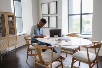 Black Woman sitting at table and filling documents