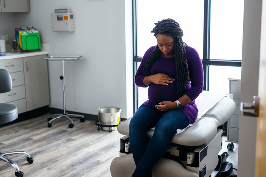 Black pregnant woman waiting in medical exam room at the Doctors office