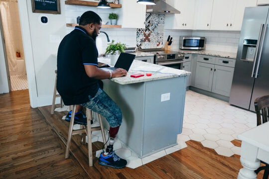 Man With Disability Working From Home On Laptop