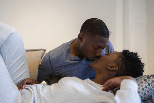 African American Couple kissing in bed