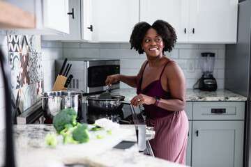 Black woman cooking in kitchen