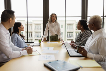 Mature Asian woman leading business team meeting