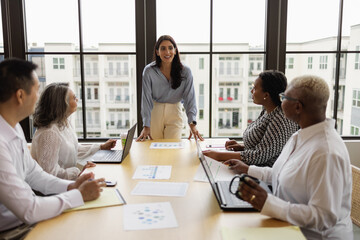 Mid Middle Eastern woman leading business team meeting