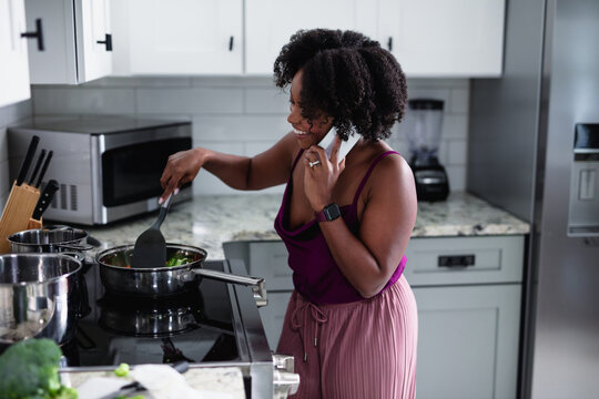 Black Woman Cooking At Talking On Phone, Multitasking 