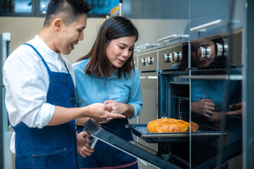 Young Asian woman crying in pain due to a knife cut in finger while chopping vegetables in kitchen...