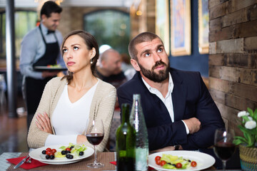 Portrait of upset minor man and woman in the restaurant on meeting
