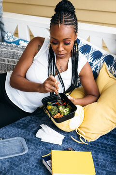 Black woman eating healthy vegetables - vegetarian 