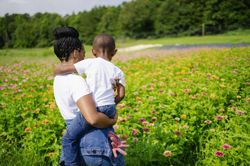 Rear view of mother and son standing in field