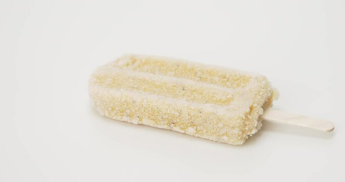 Move camera Close-up detail Top view, Ice cream popsicle sticks passion fruit ice confection melting on white background.