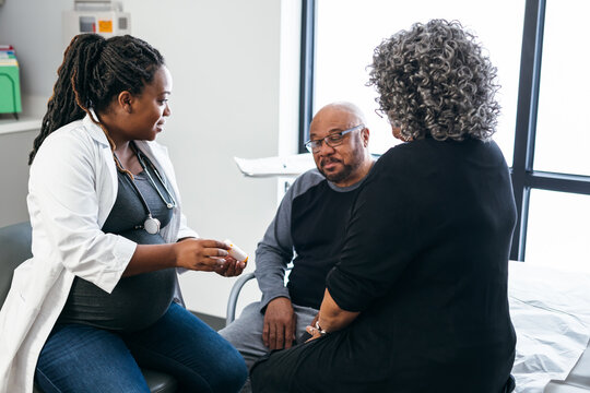 African American female doctor consults with senior medical patients about prescription drugs