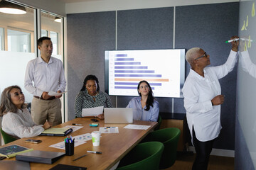Diverse business team brainstorming and collaborates in conference room, senior Black woman leadership