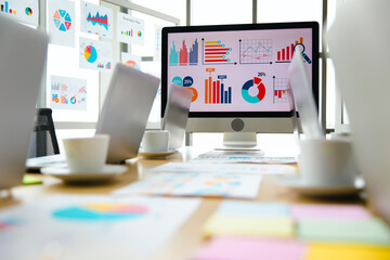 Laptop computer colorful post it paper report data graph chart documents placed on table in...