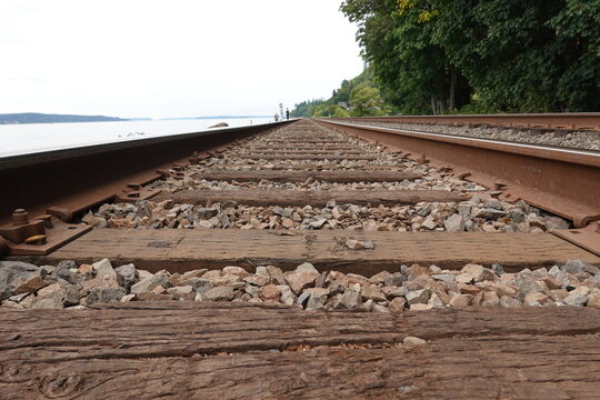 Railway track with the dirty stone on the ground.