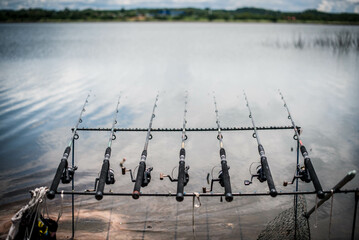 Fishing rods are lined up by the lake to wait for fish to eat bait at Nong Klang Dong Reservoir, Sriracha District, Thailand