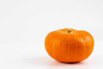 Big pumpkin on white background. Orange pumpkin on white background, isolated. Organic agricultural product, ingredients for cooking, healthy food vegan. Concept of Halloween or Thanksgiving. 