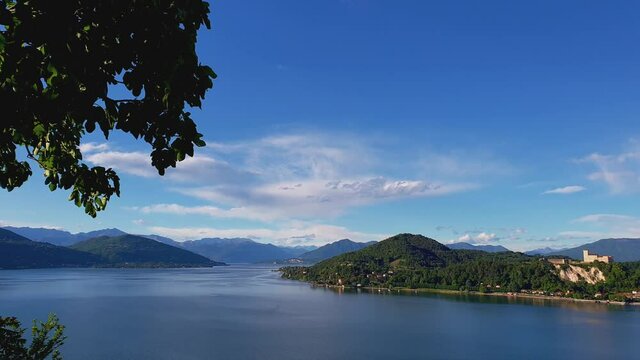 Beautiful panoramic panning view of Maggiore lake and Angera castle with Alps mountain range in background, Italy