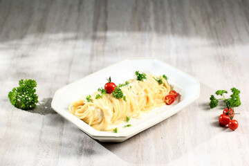 Angel Hair Pasta with Carbonara Creamy Sauce, Spaghetti Alla Carbonara with Parmesan Cheese. Served on Rectangular Plate