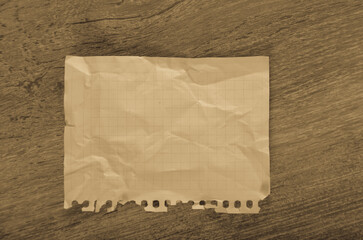 Crumpled empty torn page lying on wooden surface