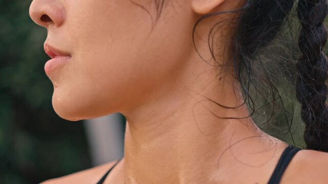 Portrait of beautiful young tired and sweaty woman boxer turning face to camera with serious look. Close up of pretty girl sportswoman looking at cam after physical training.