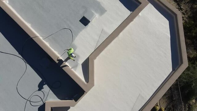 Man coating roof in outskirts of Phoenix drone video 4k.