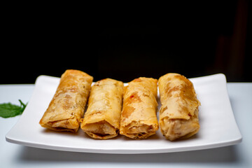 A plate of lumpia, spring rolls as Indonesian traditional food,  on a white table
