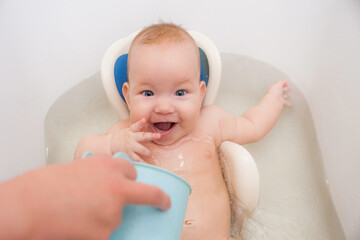 Surprised little baby swimming in the bath. American child bathroom surprised for game design. Pure water. Curly hair. Funny kid. Open mouth - 453228910