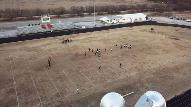 Drone video of Texas high school football field behind stadium lights