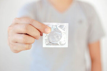 Close up man hand holding condom, health care and medical, contraception, birth contro, and or safe...