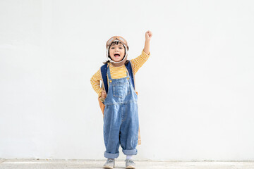 A cute little girl dressed in a cap and glasses of a pilot. The child dreams of becoming a pilot.