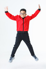 Lively cutout portrait of strong young Asian boy on red jacket and black pants happily enjoy playing of jumping up and stretching arms and legs out with smile and fun for exercise