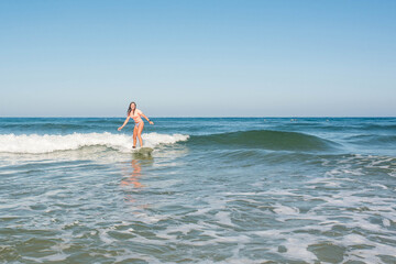 Fototapeta na wymiar pretty young female surfer in action
