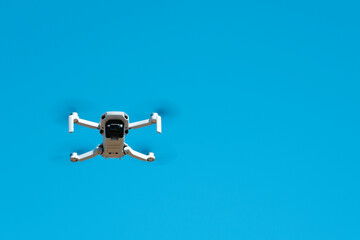 Quadcopter in flight against a blue sky