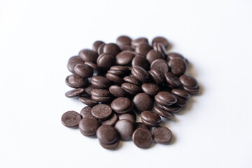 Naklejka premium Dark chocolate chips morsels heap isolated on white background
