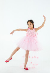 Fototapeta na wymiar Isolated full body studio shot of little cute pretty Asian ballerina kid wears pink beautiful roses flowers ballet dress and red shoes smiling posing dancing happily in front of white background