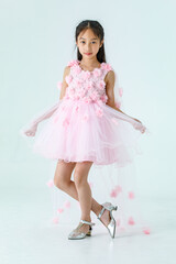 Portrait isolated studio shot of little Asian cute ballerina kid in pink beautiful ballet dress...