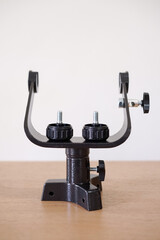 Yoke altazimuth mount, thumb screw, and vertical fine adjustment rod. Telescope parts on wooden...