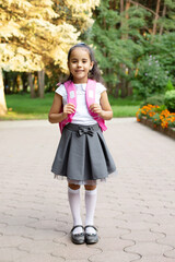 a beautiful dark-skinned girl in a school uniform and a backpack